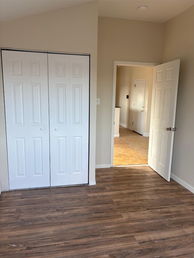 unfurnished bedroom featuring dark hardwood / wood-style floors and a closet