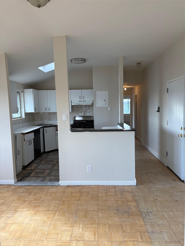 kitchen featuring backsplash, a skylight, white dishwasher, white cabinets, and kitchen peninsula