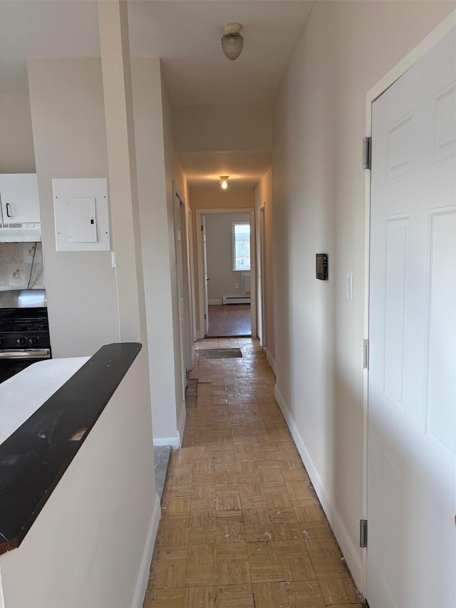 corridor featuring electric panel, light parquet floors, and a baseboard heating unit