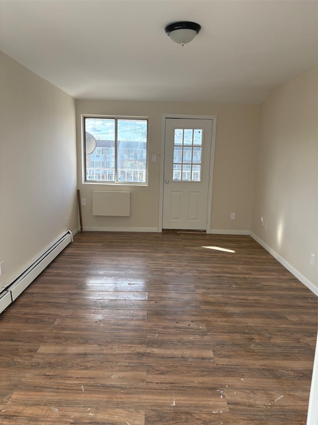 spare room with dark wood-type flooring and baseboard heating