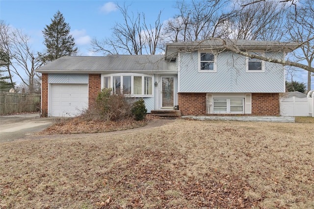 tri-level home featuring a garage and a front yard