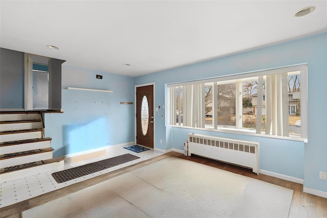 foyer entrance featuring radiator and hardwood / wood-style flooring