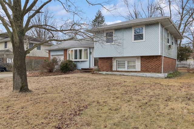 split level home featuring cooling unit and a front lawn