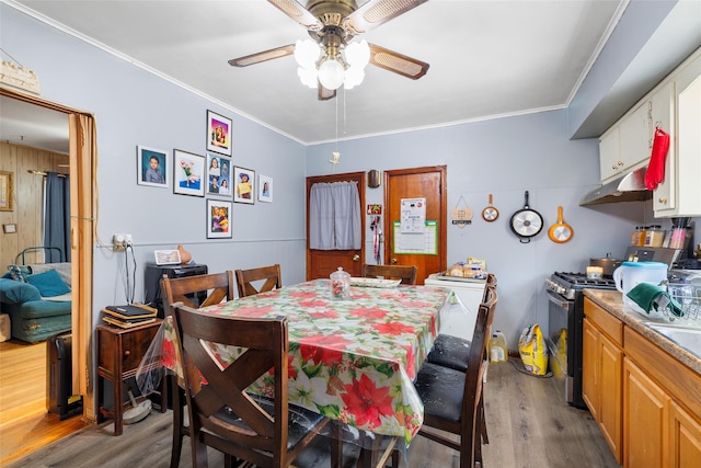 dining space featuring hardwood / wood-style flooring, ornamental molding, and ceiling fan