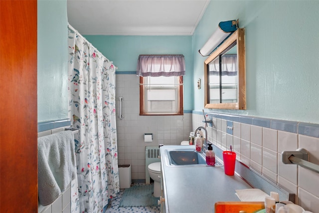 bathroom featuring radiator, curtained shower, sink, tile walls, and toilet