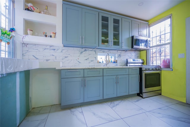 kitchen with appliances with stainless steel finishes, plenty of natural light, and backsplash