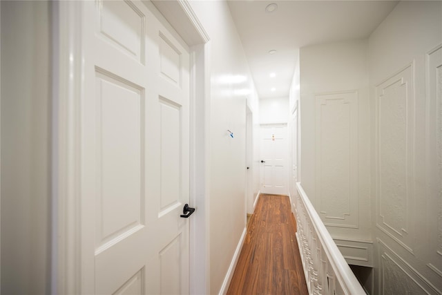 corridor with dark hardwood / wood-style flooring