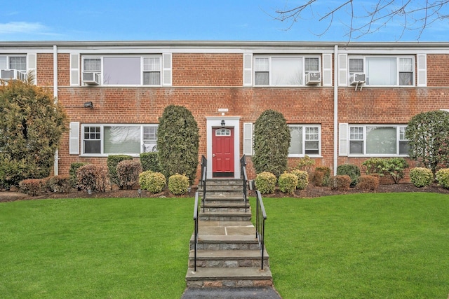 view of property with cooling unit and a front lawn