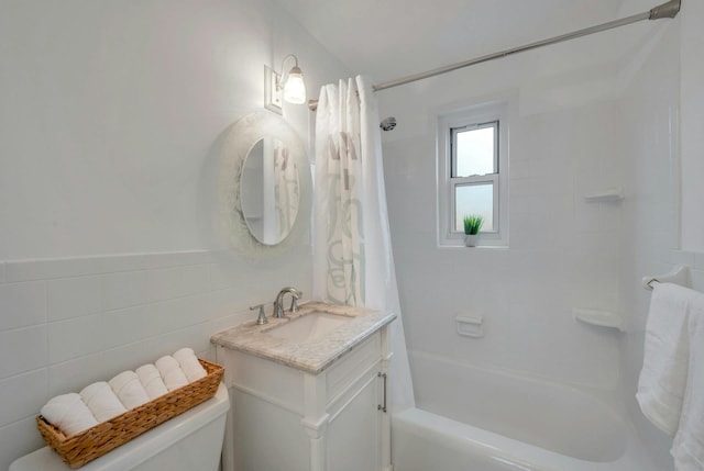 full bathroom featuring shower / bath combo with shower curtain, vanity, toilet, and tile walls