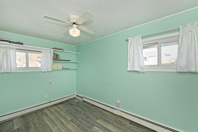 spare room with hardwood / wood-style flooring, a baseboard radiator, a textured ceiling, and ceiling fan