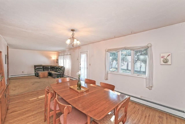 dining space featuring baseboard heating, a healthy amount of sunlight, and a notable chandelier