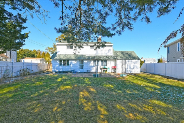 back of house with a yard and a patio