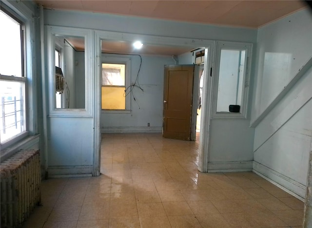 corridor featuring radiator heating unit and plenty of natural light