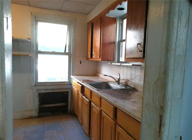 kitchen featuring sink, backsplash, and a paneled ceiling