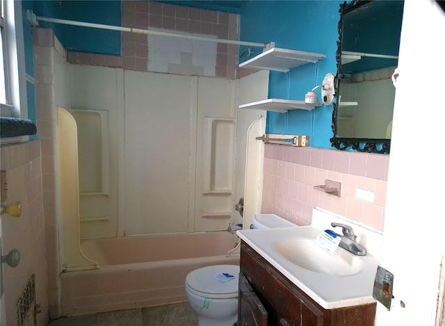 full bathroom with tile patterned floors, toilet, tub / shower combination, tile walls, and vanity