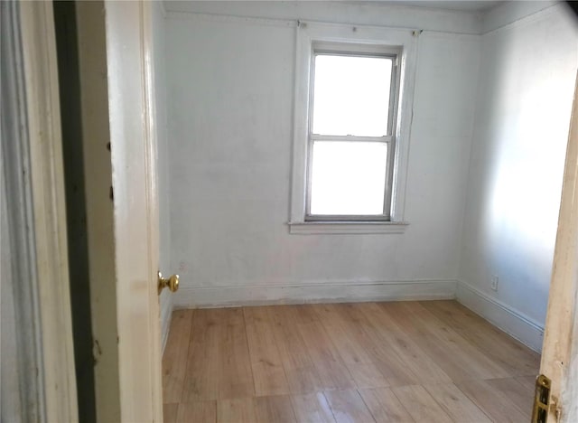 spare room featuring a healthy amount of sunlight and light hardwood / wood-style floors