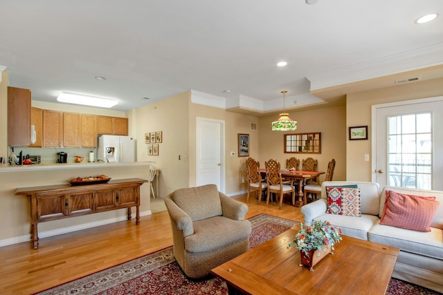 living room featuring ornamental molding and light hardwood / wood-style floors