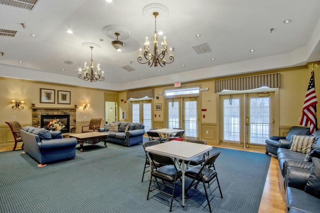 living room featuring a fireplace, french doors, and a chandelier