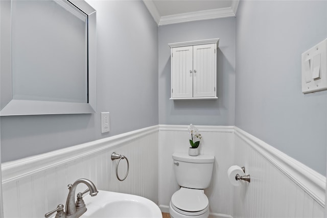 bathroom with ornamental molding, toilet, and sink