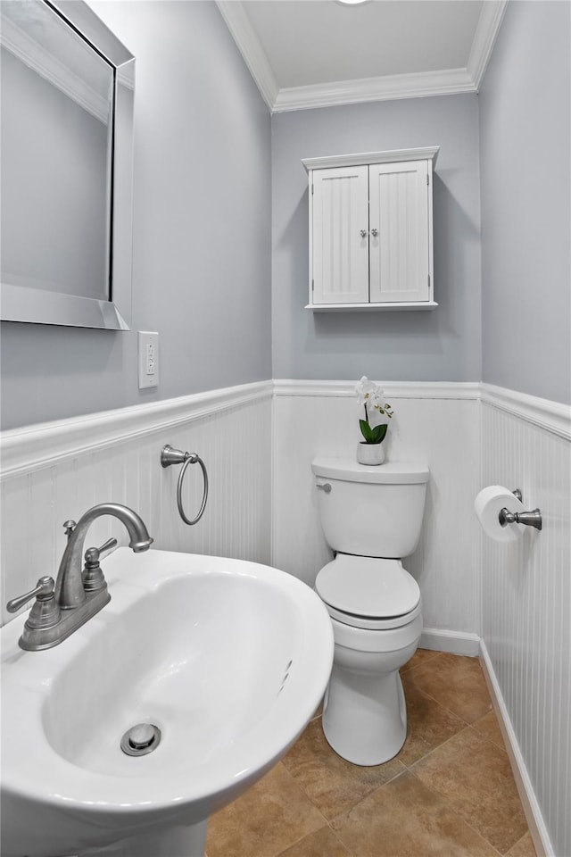 bathroom featuring tile patterned flooring, ornamental molding, sink, and toilet