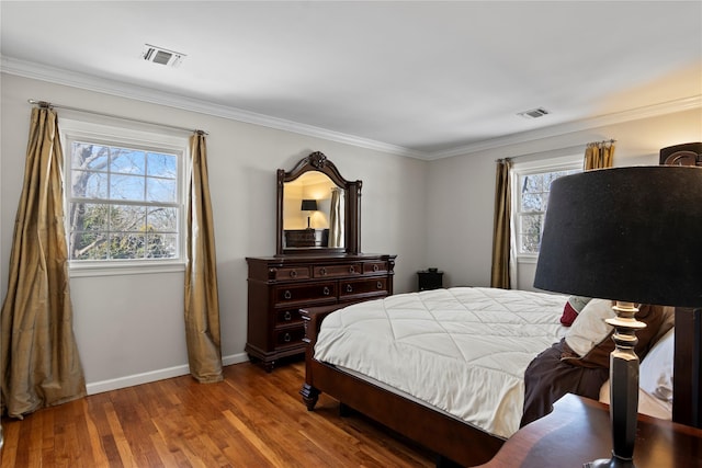 bedroom with multiple windows, hardwood / wood-style flooring, and crown molding