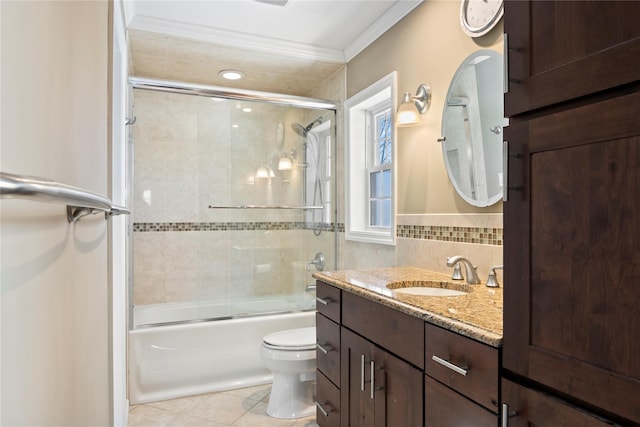 full bathroom featuring bath / shower combo with glass door, vanity, toilet, crown molding, and tile patterned floors