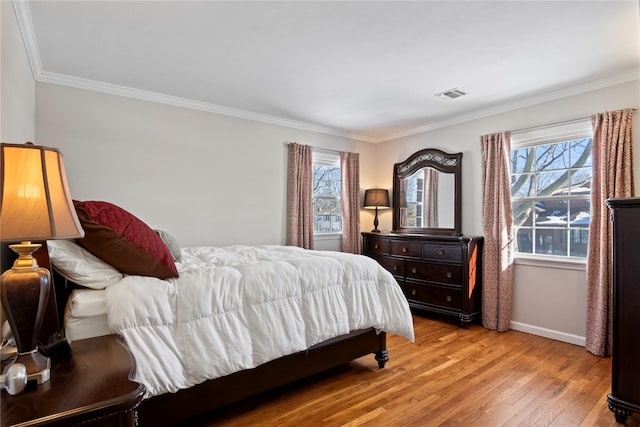 bedroom with multiple windows, crown molding, and light wood-type flooring