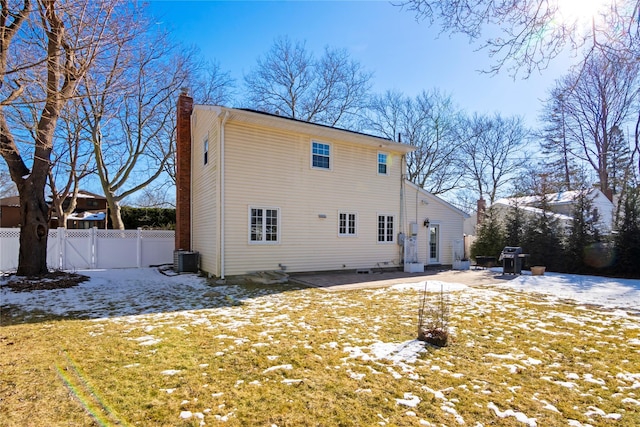 snow covered back of property featuring cooling unit