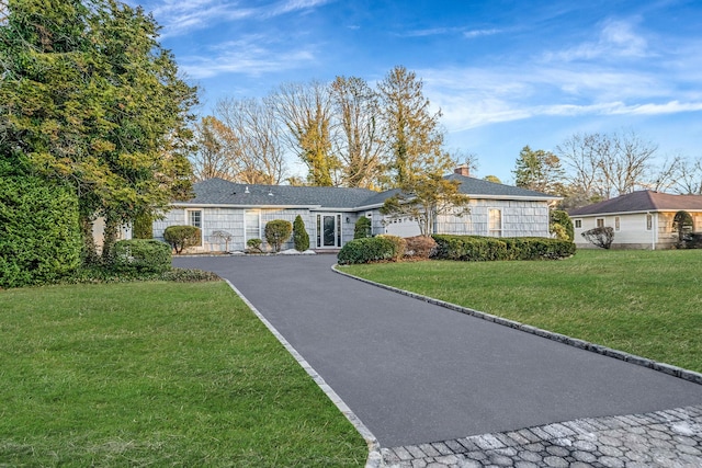 single story home featuring a garage and a front lawn