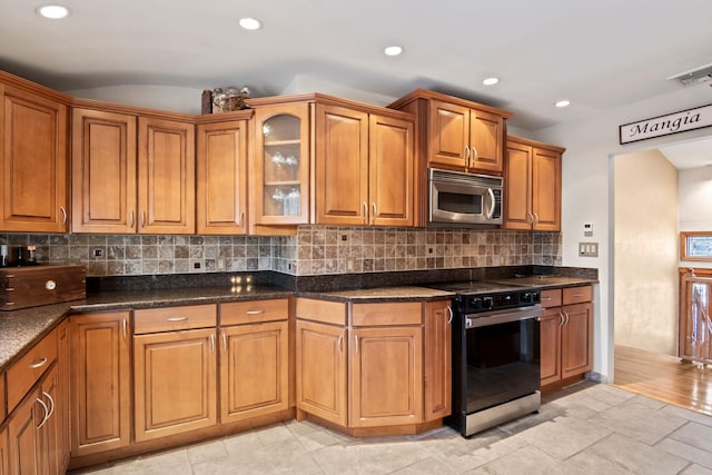 kitchen with tasteful backsplash, black range with electric cooktop, and dark stone countertops