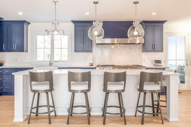 155 Pinewood Rd, Cutchogue, NY 11935 - kitchen with a kitchen island, range hood, tasteful backsplash, a sink, and light wood-style floors