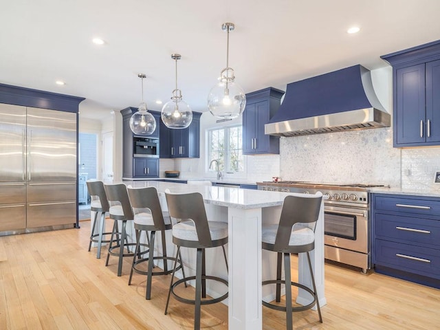 155 Pinewood Rd, Cutchogue, NY 11935 - kitchen with wall chimney range hood, light wood-style floors, stainless steel stove, and blue cabinets
