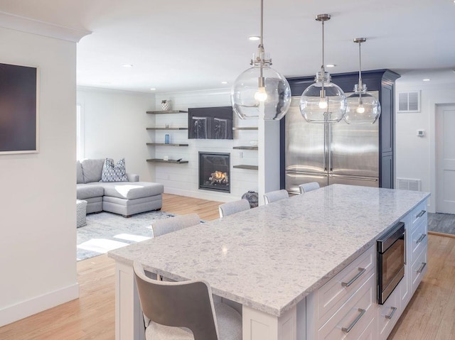 155 Pinewood Rd, Cutchogue, NY 11935 - kitchen with a kitchen island, visible vents, light stone counters, and built in microwave