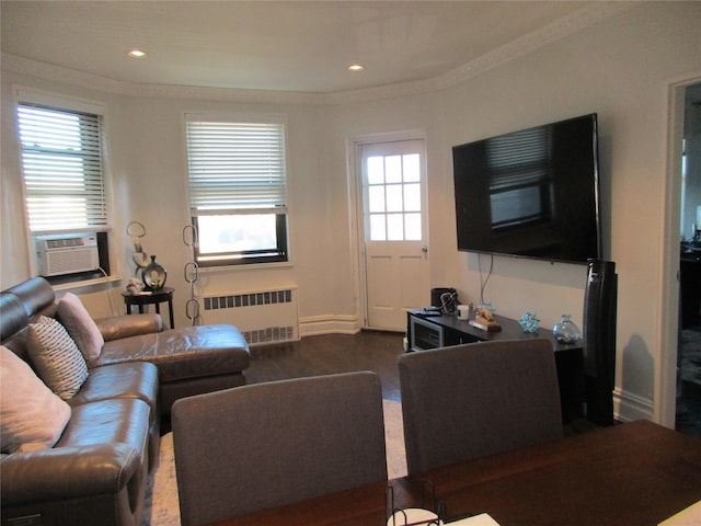 living room with wood-type flooring, radiator, a wealth of natural light, and crown molding