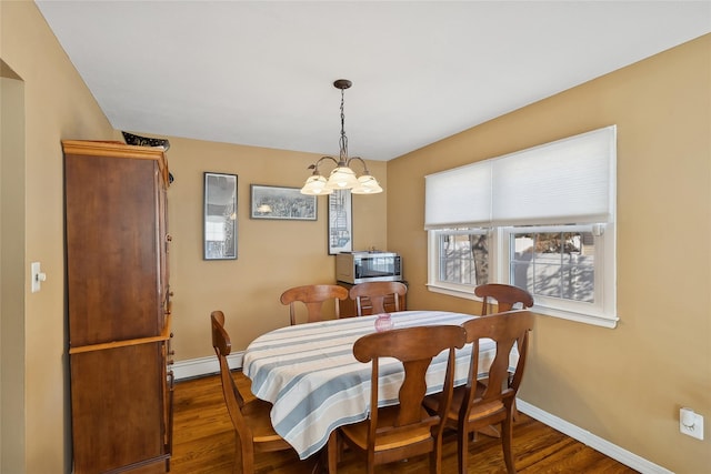 dining room with a baseboard heating unit, dark wood-type flooring, and an inviting chandelier