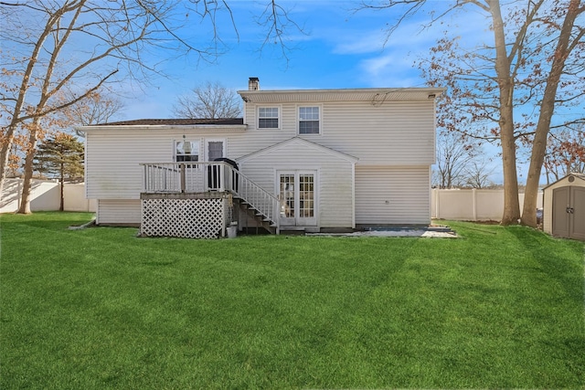 rear view of house featuring a wooden deck, a yard, and a storage shed