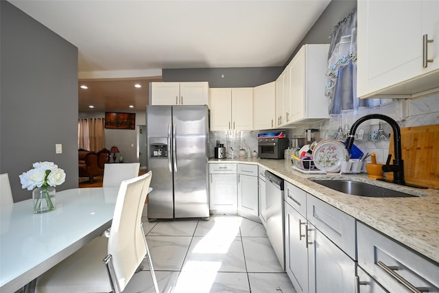 kitchen featuring tasteful backsplash, appliances with stainless steel finishes, sink, and white cabinets