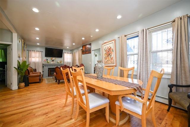 dining area featuring a fireplace and light hardwood / wood-style floors