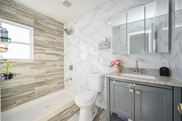 bathroom featuring hardwood / wood-style floors, a shower, tile walls, vanity, and toilet