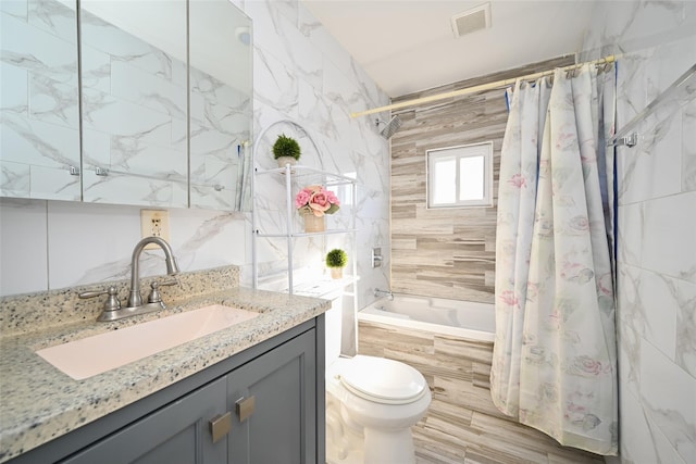 full bathroom with shower / bath combo, tile walls, vanity, and toilet