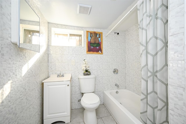 full bathroom with tile walls, shower / bath combination with curtain, vanity, toilet, and tile patterned floors