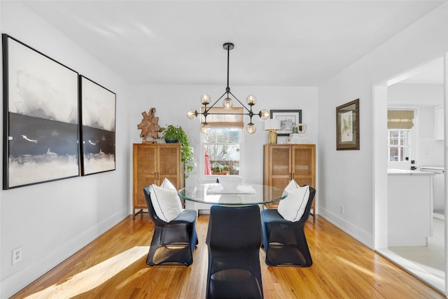 dining room featuring a notable chandelier and light wood-type flooring