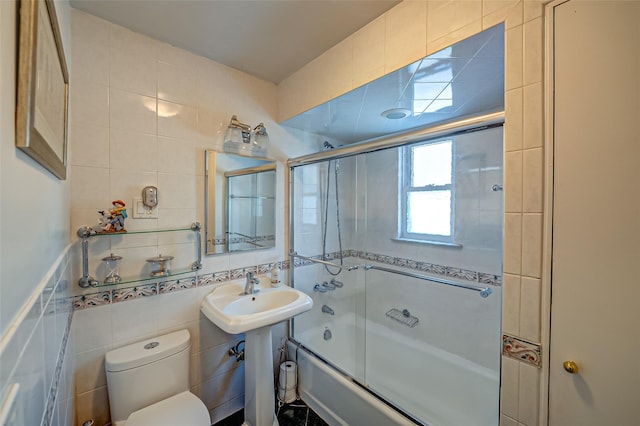 full bathroom with enclosed tub / shower combo, sink, tile walls, and toilet