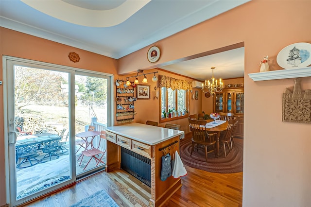 playroom featuring an inviting chandelier, a wall mounted AC, and light hardwood / wood-style flooring