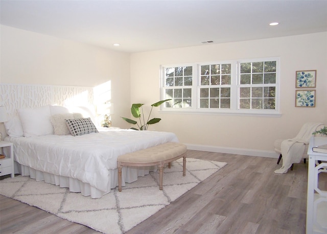 bedroom featuring multiple windows and wood-type flooring