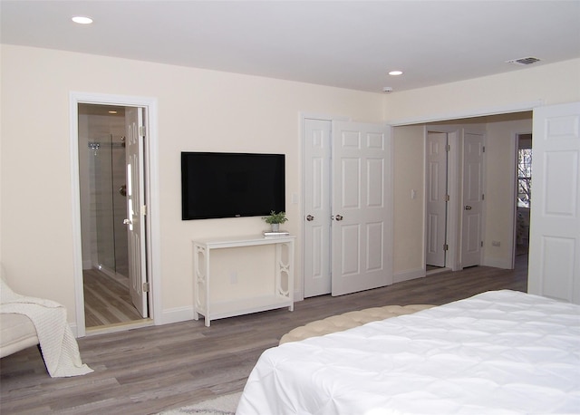 bedroom featuring hardwood / wood-style flooring and connected bathroom