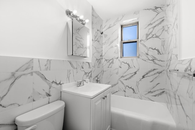 full bathroom featuring tiled shower / bath combo, vanity, tile walls, and toilet