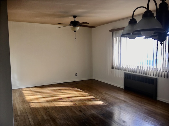 empty room with ceiling fan, radiator heating unit, and dark hardwood / wood-style flooring