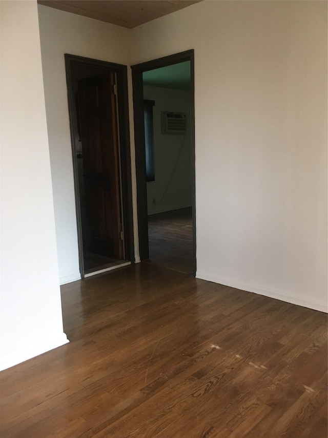 spare room with dark hardwood / wood-style flooring and a wall mounted AC