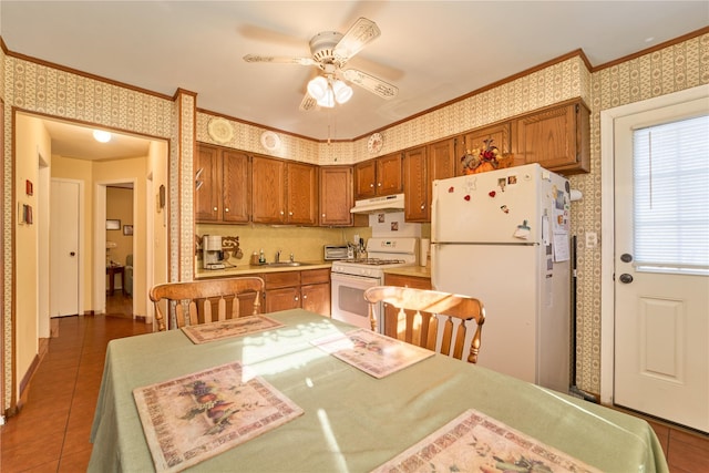 kitchen featuring sink, crown molding, white appliances, ceiling fan, and dark tile patterned flooring